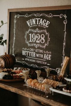 an old fashioned sign is on the wall above a buffet table with bread and pastries