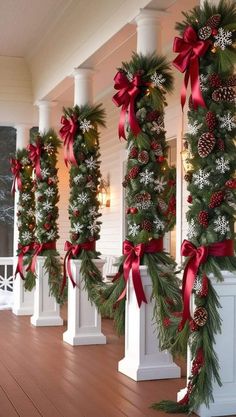 christmas decorations on the porch with red bows and pineconis hanging from columns in front of them