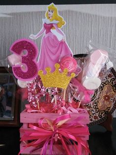 there is a pink and gold birthday cake in the shape of a princess on display