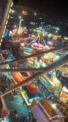 an aerial view of a carnival at night with people on the rides and fairground