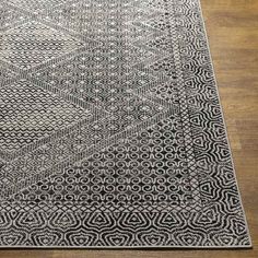 a black and white rug on top of a wooden floor