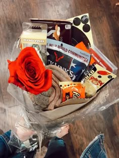 a person sitting on the floor holding a bouquet of items