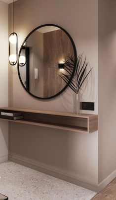 a round mirror hanging on the wall above a wooden shelf with a plant in it