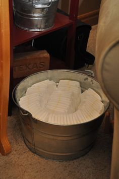 a metal bucket filled with lots of white marshmallows on top of a carpeted floor