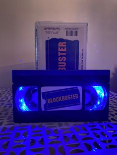 a blue tape recorder sitting on top of a table next to a cd case with the word blockbuster printed on it