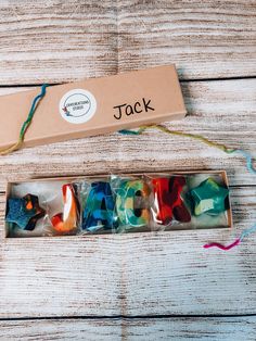 the box is filled with different colored glass beads and string, along with some other items