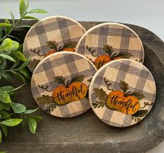 four wooden coasters decorated with pumpkins and the words happy thanksgiving