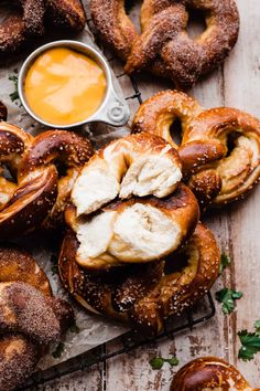 an assortment of bagels with cream cheese on them and some dipping sauce in the background