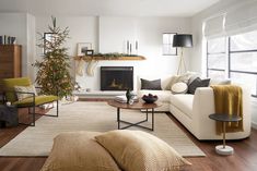 a living room filled with furniture and a christmas tree in the corner near a fire place