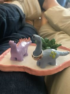 two toy dinosaurs are sitting on a tray