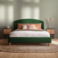 a bed with green headboard and pillows on top of it in a room that has hardwood floors