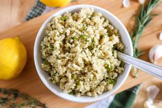 a bowl filled with rice next to lemons and garlic