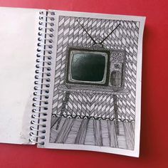 an open notebook with a drawing of a tv on it