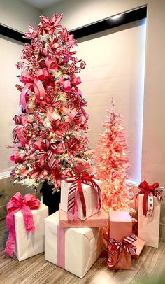 a christmas tree with pink and white presents next to it