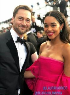 a man in a tuxedo standing next to a woman in a pink dress