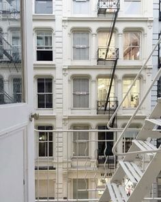 an apartment building with stairs leading up to the second floor