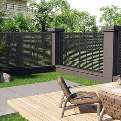 a wooden deck with two chairs and a table on it in the middle of a yard