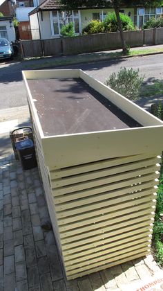 a large box sitting on the side of a road next to a brick walk way