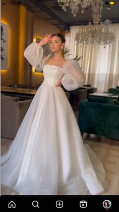 a woman in a white wedding dress posing for the camera with her hands on her head