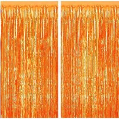 two orange tinsel curtains with fringes hanging from the top, and one in the bottom