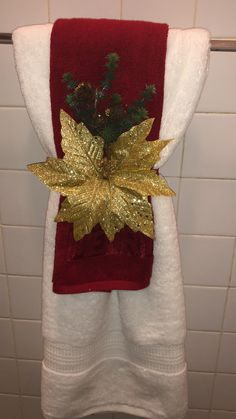 a red towel with gold leaf decoration hanging from it's side in a bathroom