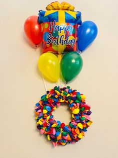 balloons, a wreath and a birthday cake on a table