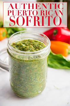 a jar filled with green pest sitting on top of a counter next to some vegetables