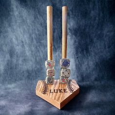 two wooden baseball bats on top of a base with the word duke engraved on it