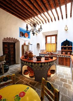 an old fashioned kitchen with lots of wood and tile on the floor, including a table