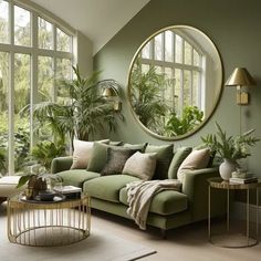 a living room filled with lots of green furniture and plants in the window sill