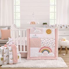 a baby crib bedding set with rainbows and clouds