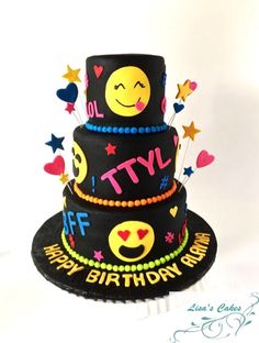 a three tiered birthday cake with smiley faces and stars on the top is black