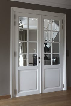 two white double doors with glass panes on each side and one open door to the other