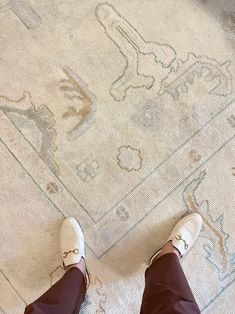 a person standing on top of a rug with their feet up in front of the carpet