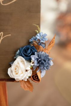 a wooden sign with blue and white flowers on it