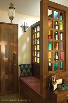 a wooden bench sitting under a window next to a light fixture in a living room