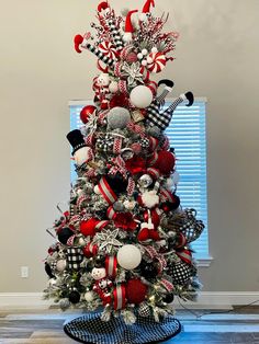 a decorated christmas tree with red, white and black ornaments on it's base