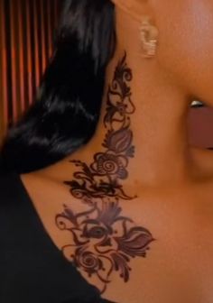 the back of a woman's neck with tattoos on it