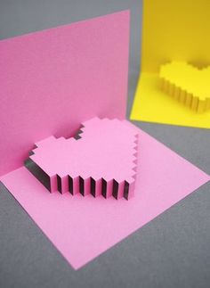 a pink card with black lines on it and a yellow block in the middle that has been cut out