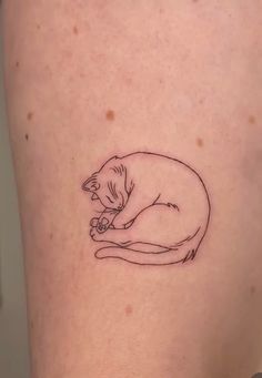 a cat tattoo on the back of a woman's thigh