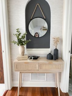 a wooden table topped with a mirror next to a plant