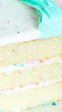 a slice of cake with white frosting and sprinkles