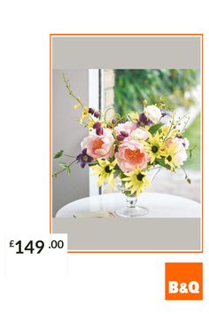 a vase filled with flowers sitting on top of a white table next to a window