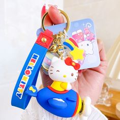 a hello kitty keychain is being held by someone