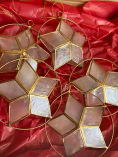 four glass ornaments are sitting on a red cloth