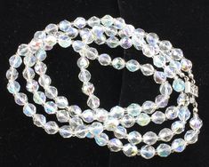 Vintage Aurora Borealis Crystal Double Strand Necklace. Made in the 1960s, this beaded necklace features faceted round glass beads with aurora borealis finish finished with a silvertone filigree box catch. The crystal beads are 7.4mm in diameter and the necklace is 19.5 inches in length. ERA: Mid Century, 1960s METAL/MATERIALS: Aurora Borealis Crystals and Silver Tone Alloy Metal HALLMARK: None MEASUREMENTS: 19 1/2 inches long, with 7.4 mm beads CONDITION: Very good condition, with minor surface wear consistent with age. Previously owned and worn. Arrives in a gift box! Faceted Beads Crystal Necklace For Party, Party Crystal Necklaces With Faceted Beads, Round Crystal Necklaces With Faceted Beads For Party, Faceted Crystal Round Necklaces For Party, Faceted Crystal Necklaces For Party, Faceted Crystal Necklace For Party, Faceted Round Bead Crystal Necklace For Party, Aurora Borealis Crystal, Double Strand Necklace