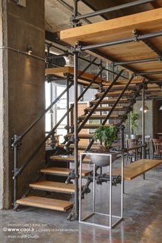 an industrial style staircase with metal handrails and wood steps