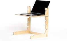 a laptop computer sitting on top of a wooden stand