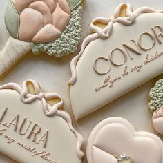 decorated cookies with names and flowers are on a white tablecloth, next to each other