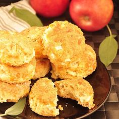 some biscuits are on a plate with apples in the background